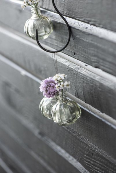 Liten söt vas i glas. Med metall ögla upptill så vasen kan hänga. Dekorerad runt om med vackert dekor mönster i glaset. För blom