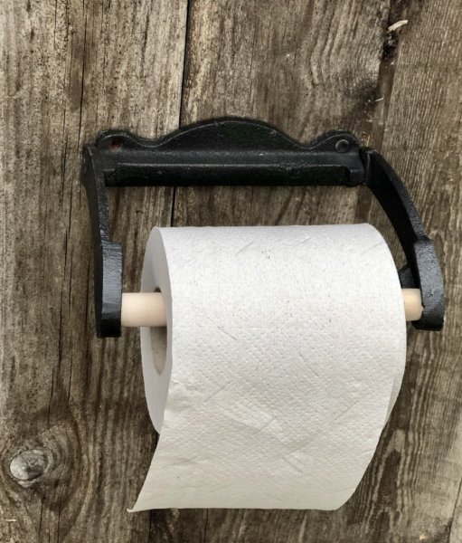 Gammeldags hållare till toalettpapper i järn med trä pinne. I stadig och stabil modell med diskreta mönster och text upptill. Gå