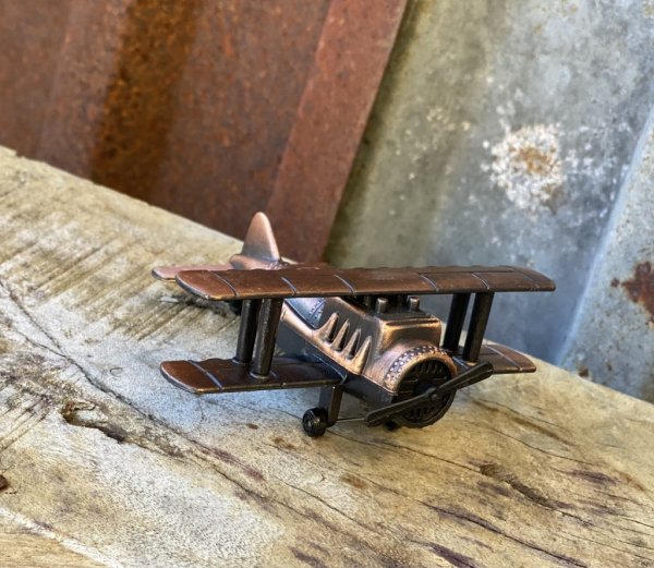 Flygplan i metall, gammeldags vacker modell av ett dubbelvingat flygplan. Går i en mörk koppar antik nyans. Flygplanet har en pe