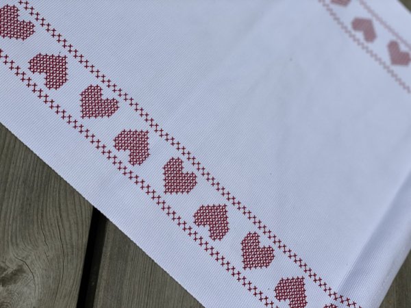 Vit duk/bordstablett med röda hjärtan. Lika passande mitt på bordet som att placera under varje tallrik eller alt på en bricka.
