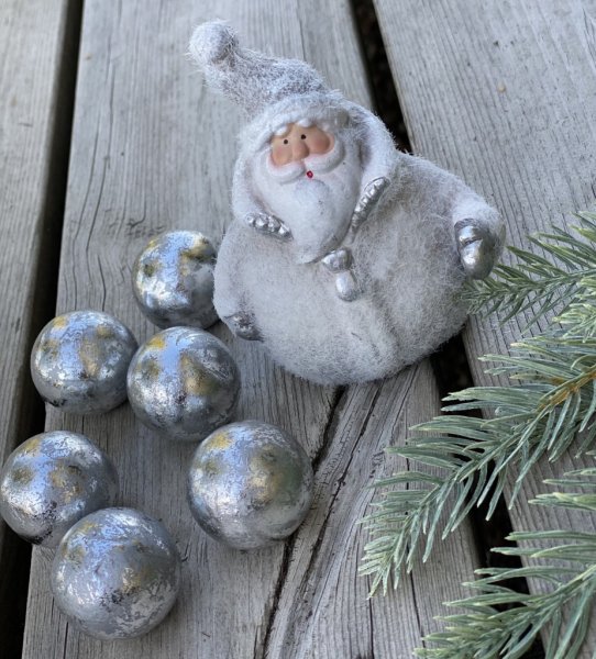 Vit tomte med silver inslag. Detalj full och söt tomte att dekorera med. Tomtens kläder är päls beströdda. Mäter 10,2cm