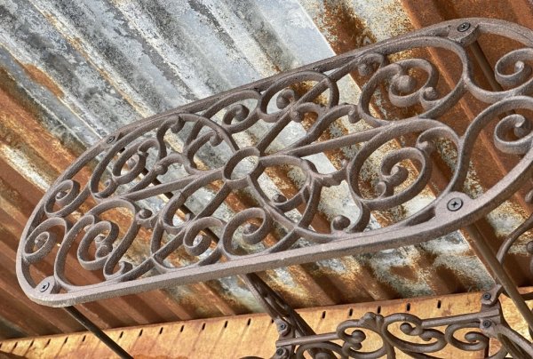 Vackert snirkligt dekorerad oval pedistal / sidebord i järn. Går i en antik stil och design och en nyans av ruffigt brunt. För b