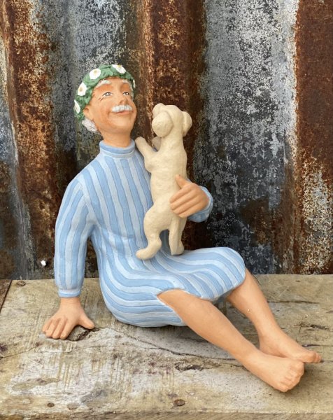 Karl-Anton med midsommarkrans på huvudet och en söt hundvalp i knät. Hundvalpen är lös i famnen så den kan placeras som man vill