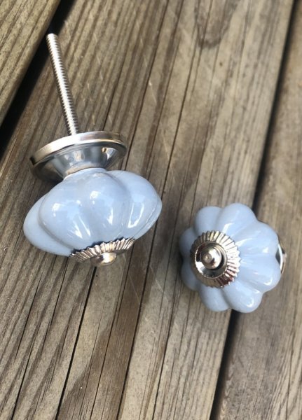 Blomformad porslinsknopp lätt cream vit med krage i silver. Mäter Längd 8cm Bredd ca4,4cm Säljes per styck en och en