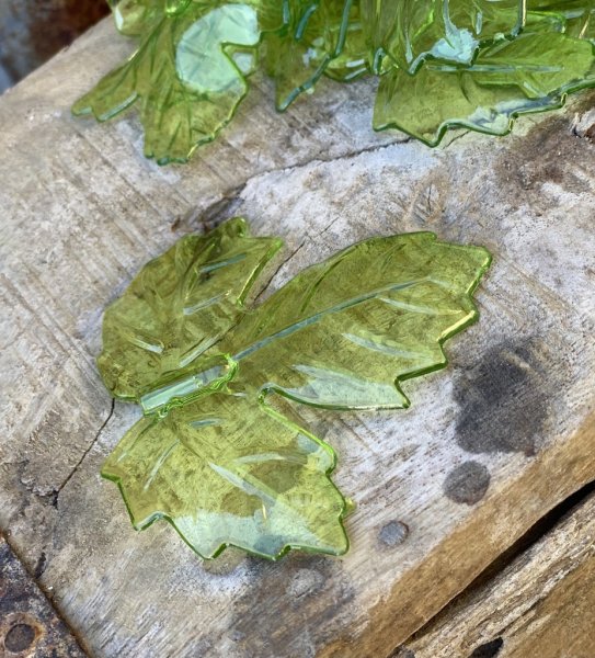 Gröna löv / blad i ask att dekorera med. Tillverkade i hård plast och går i en klar grön nyans. Säljes i ask om ca löv/blad g