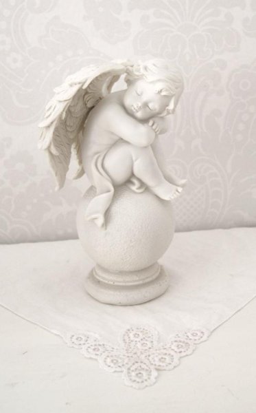 Vit ängel sittande på klot ansikte höger