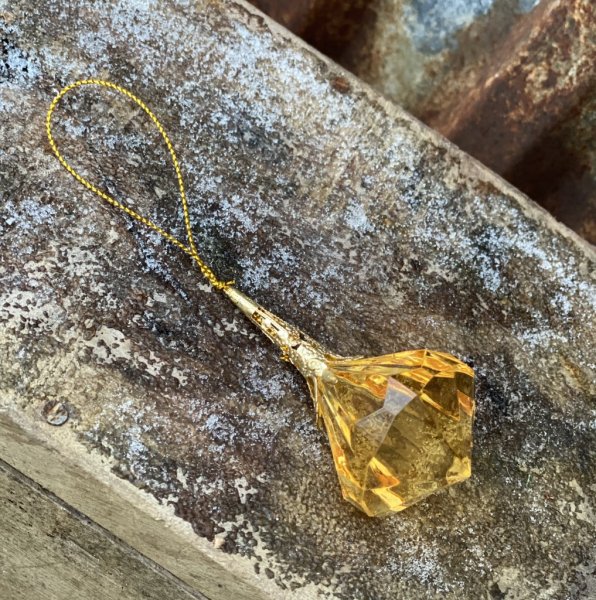 Diamant hänge i guld. Vackert utformad med guld band upptill. Att hänga och dekorera med eller låta ligga på ett fat med fler pr