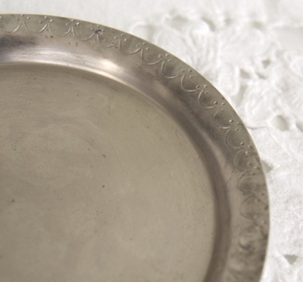 Rund mindre bricka ljusfat i orientalisk stil med en liten kant. Tyngre modell i silver färgad metall med vacker mönster runt om