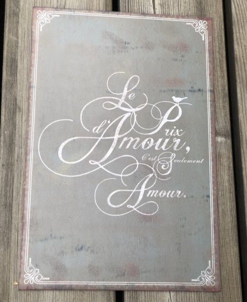Vacker grå plåt skylt med vit Fransk text  Le Amour... och fabriks slitna inslag. Väggfäste för upphängning på baksidan.    Höjd