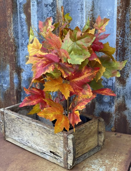 Vacker verklighetstrogen kruka med höstlöv lönn löv i färgrika blandade nyanser. Välarbetad och verklighetstrogen konstgjord mod
