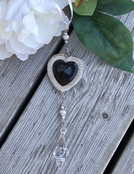 Vackert dekorations hänge hjärtformad med diamant liknande prismor . Trädda på tråd hängande på vitt siden band. Stilfullt att h