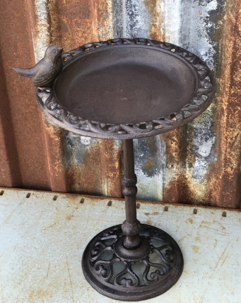 Fågelbad på fot, högre modell tillverkad i järn och dekorerad med fågel upptill på kanten. Går i en brun lätt ruffig nyans och s
