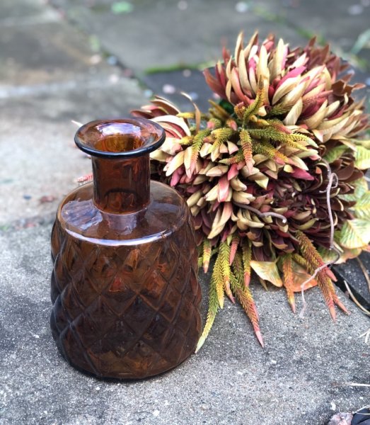 Vacker flaska / vas i glas. Brun färgad med gammeldags retro mönster runt om. För blommor eller enbart vacker dekoration. Höjd: