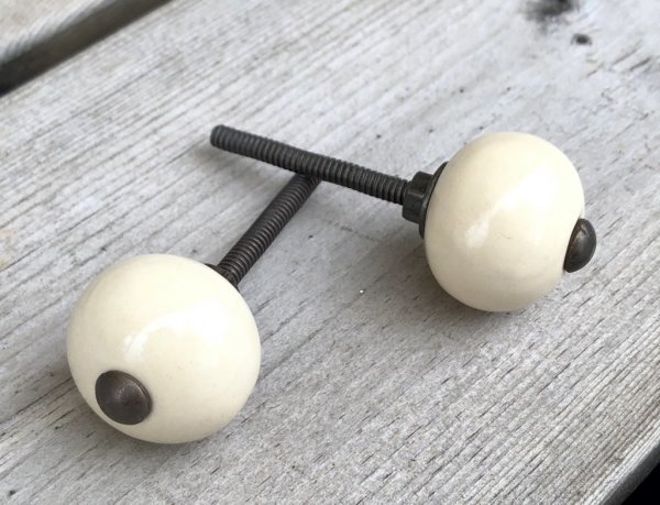 Svamp formad lätt rundad mindre cream vit keramik knopp i matt nyans. Med stomme i antik guld. Mäter Längd: 6,5cm Bredd: ca 3c