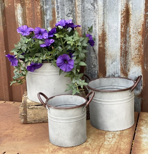 Zink kruka i rund modell med handtag för plantering och dekoration. Går i en ruffig zink grå nyans med fabriks skavda inslag och