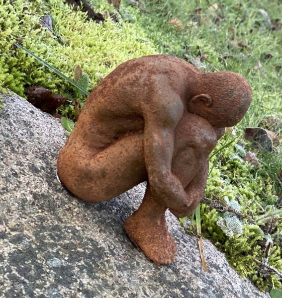 Jordens man, rostig staty/figur av en man i rost som sitter ihop kurad. Detaljrik och välarbetad. Ruffigt rostig modell. Höjd: