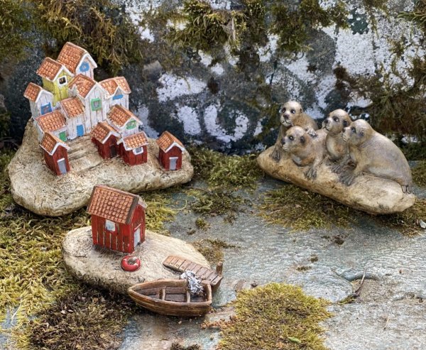 Skärgårds ö med hus och fiskebodar. Välarbetad och detalj fullt utformad med fina detaljer runt om. Går i mjuka nyanser med driv
