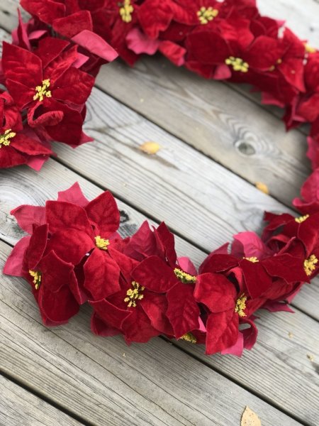 Vacker lång girlang med röd julstjärna poinsetta. Tät girlang som gör sig lika bra på väggen, runt spiselkransen som till duknin