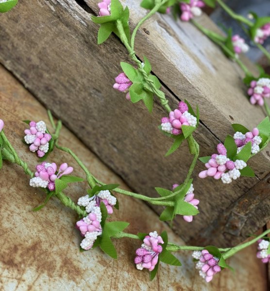 Grön girlang med rosa och vita bär buketter med gröna blad. Girlangen har formbar metall stomme, så girlangen kan lätt viras och