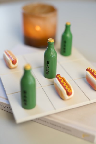 Tre i rad spel med öl flaskor och korv med bröd