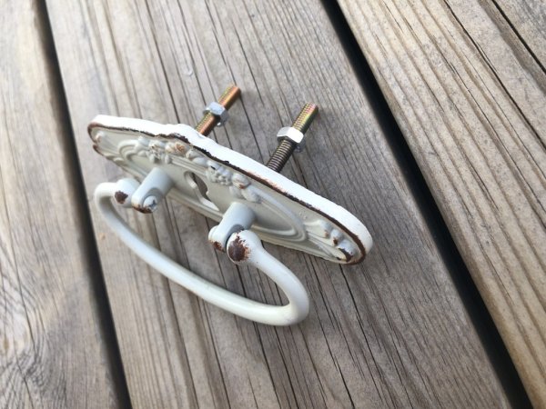 Gammeldags handtag med fina detaljer . Går i en ruffig cream vit/ beige nyans med rost bruna inslag. Med ledad bygel framtill. P