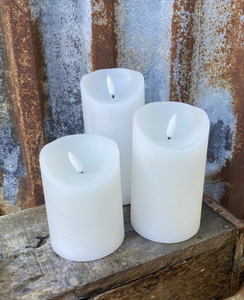 Vita cylinderformade ljus/led ljus , riktigt vaxljus därav skiftande i mörka och ljusa nyanser. Batteri drivna med timer funktio