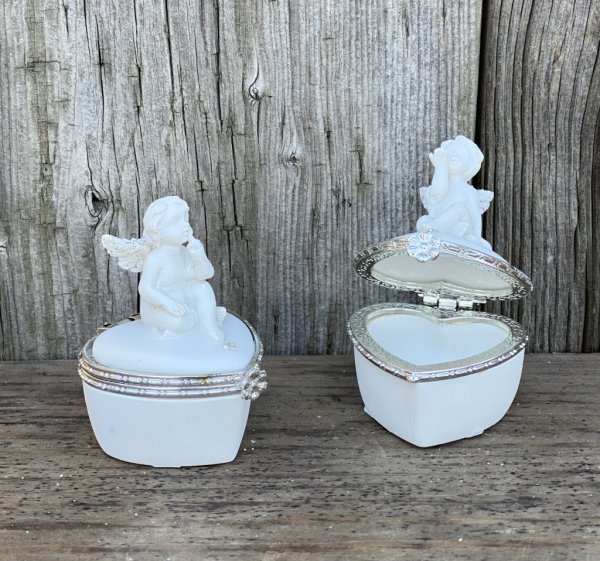Vit hjärtformad ask med ängel upptill. Fin modell med silver detaljer, glitter och diamant liknande sten. Finns i två olika mode