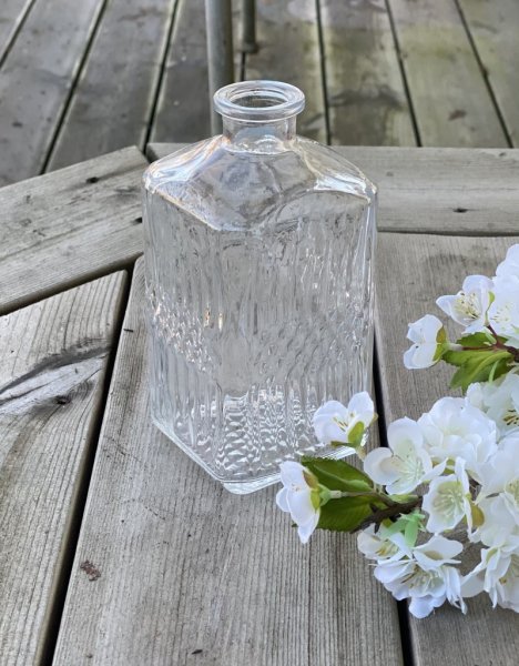Vas / flaska i kantig högre modell med mönster. Passande för den ensamma blomman/kvisten alt den mindre buketten. Höjd: 16cm Br