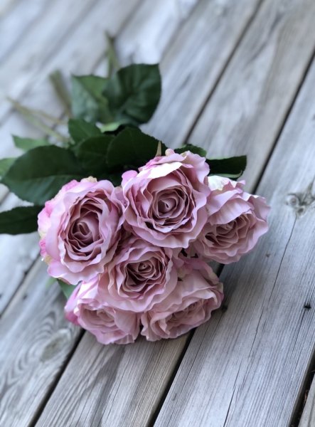 Vacker rosa ros med lång stjälk, gröna blad och fyllig rosa med vågiga blad Välarbetad vacker konstgjord ros med hög verklighets