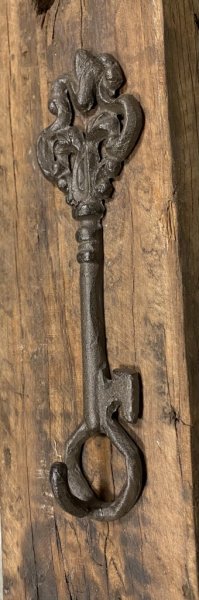 Krok i gjutjärn formad som en nyckel. Med dekorerat krön och krok nertill. Går i en mörk brun nyans. Höjd: 18,5cm Bredd: 6cm Dj