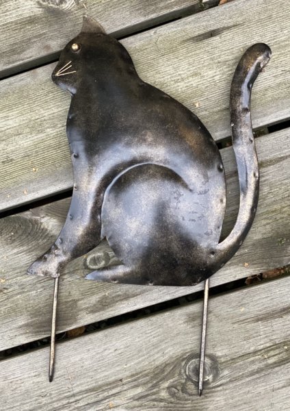 Katt sittande i hamrad plåt . Att dekorera med eller sätta efter vägen som trafik varnare för att få folk att sänka farten. Går