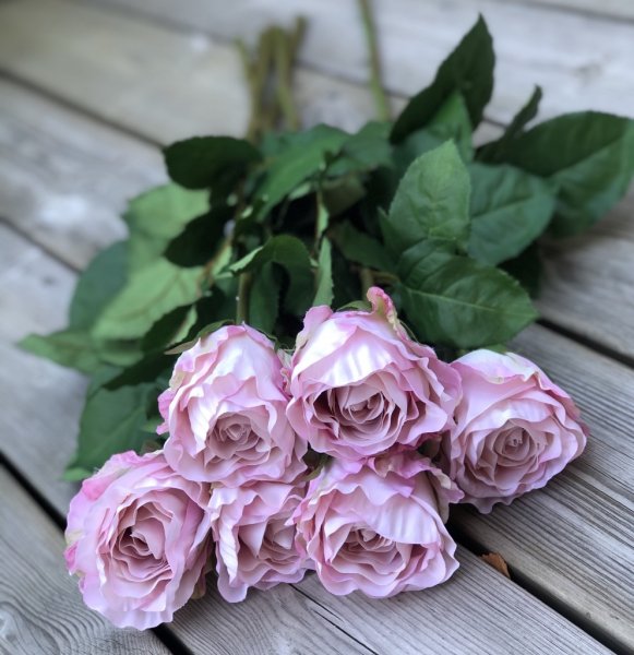 Vacker rosa ros med lång stjälk, gröna blad och fyllig rosa med vågiga blad Välarbetad vacker konstgjord ros med hög verklighets