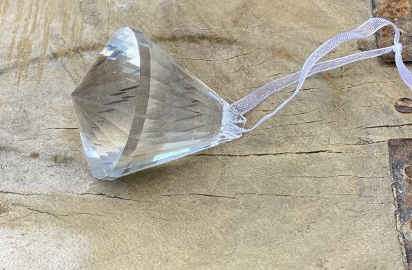 Vackert dekorerad prisma i glas. Med fina slipningar runt om som reflekterar vackert i solljus. Band upptill att hänga prisman