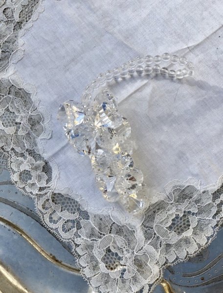 Vackert dekorations hänge med klara diamant formade prismor trädda på tråd. Prismorna är formade som en klase med vackert fallS