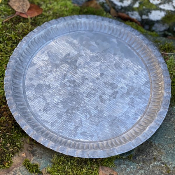 Rund bricka / ljusfat i zink med en lätt dekorerad kant runt om. Finns i två olika storlekar -Större -Mindre För servering, dek