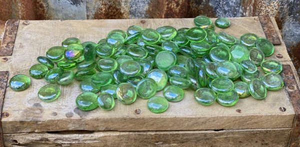Gröna lätt skimrande glasstenar. I rundad lätt platt/oval modell. Att dekorera med i vattenbad, blomsterarrangemang, ljusdekorat