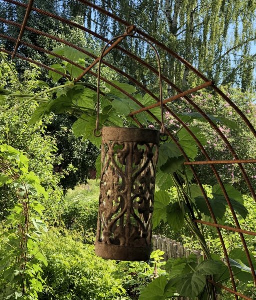 Vacker antik lykta i rund modell med cylinder glas inuti. Lyktan kan både stå samt hänga i den ledade bygeln upptill. Dekorerad