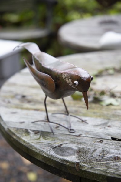 Brun fågel i hamrad plåt/metall . Att dekorera med utomhus som inomhus. I modell som både kan stå och sättas fast på väggen. M