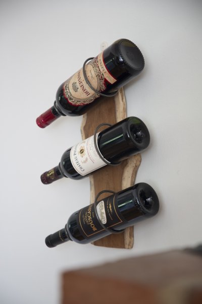 Vackert vinställ i väggmodell. Tillverkat i vackert trä med tre hållare. Hållarna för vinet är i metall ruffiga grå svarta. Mät