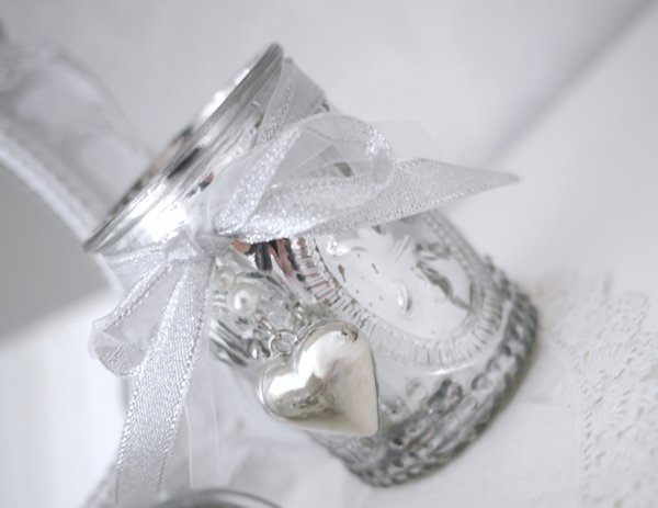 Ljusglas i fattigmanssilver . Dekorerat i glaset med mönster av en fransk lilla och med en rosett av sidenband med ett större hj