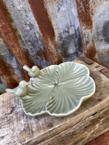 Vacker fat blomma i porslin med fåglar på kanten