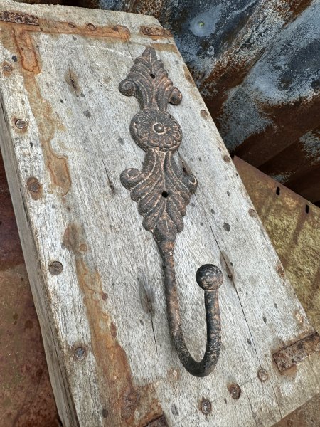 Rostig järn krok med dekorerad rygg