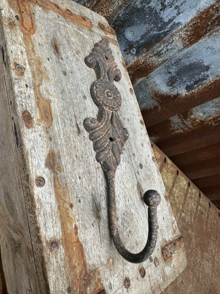 Rostig järn krok med dekorerad rygg