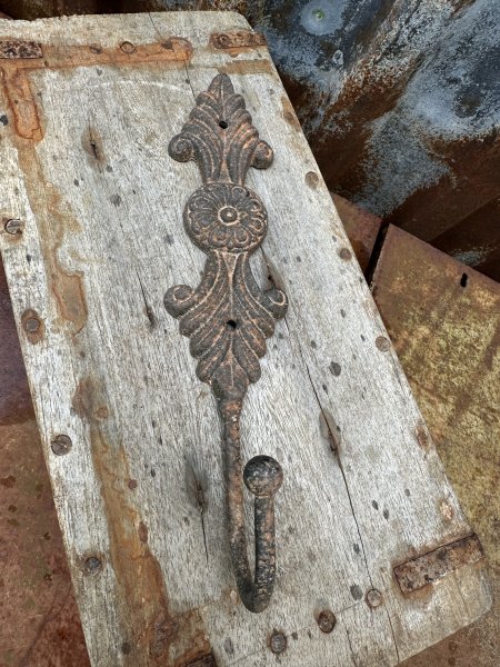 Rostig järn krok med dekorerad rygg