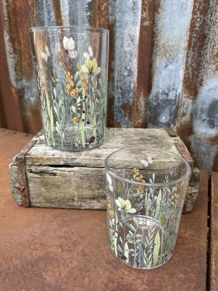 Vacker ljuslykta till lika vas med blommor och fjärilar