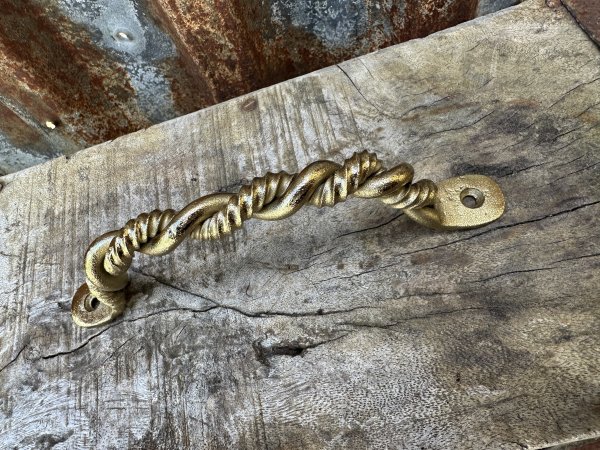 Tvinnat elegant handtag i guld 