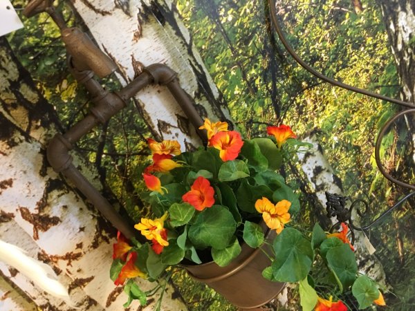 Vacker krasse konstblomma/ växt med blommor och gröna blad. Står i en plastad innerkruka som med fördel kan ställas i en större