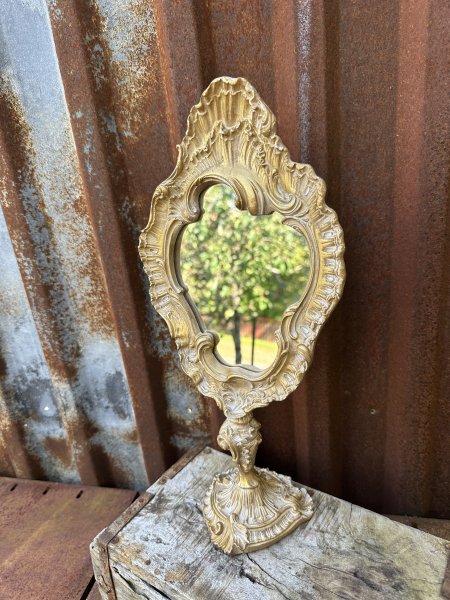 Stående guld färgad spegel på fot