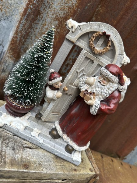 Tomte och pojke vid ytterdörr med belysning