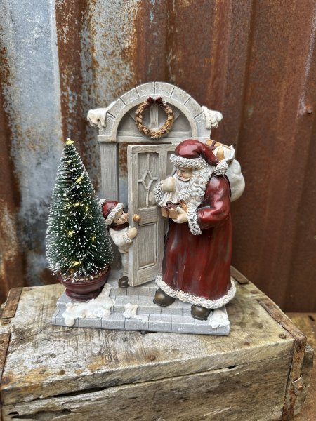 Tomte och pojke vid ytterdörr med belysning